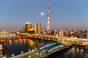 Fototapeta na wymiar Tokyo Skytree and Sumida river in sunset sky with full moon.