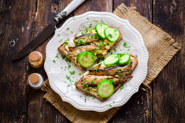 Sandwiches with sprats and fresh cucumbers.
