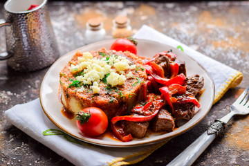  Beef goulash with sweet peppers and rice garnish.