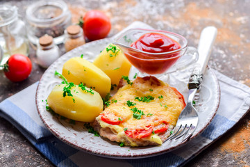 Baked pork steak with tomatoes and cheese.