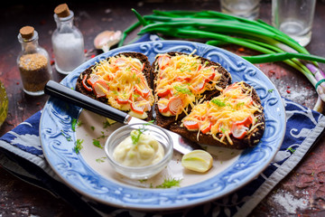 Tartas with crab sticks, grated cheese and herbs.