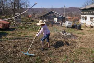 Woman farmer burning cut branches and leaves
