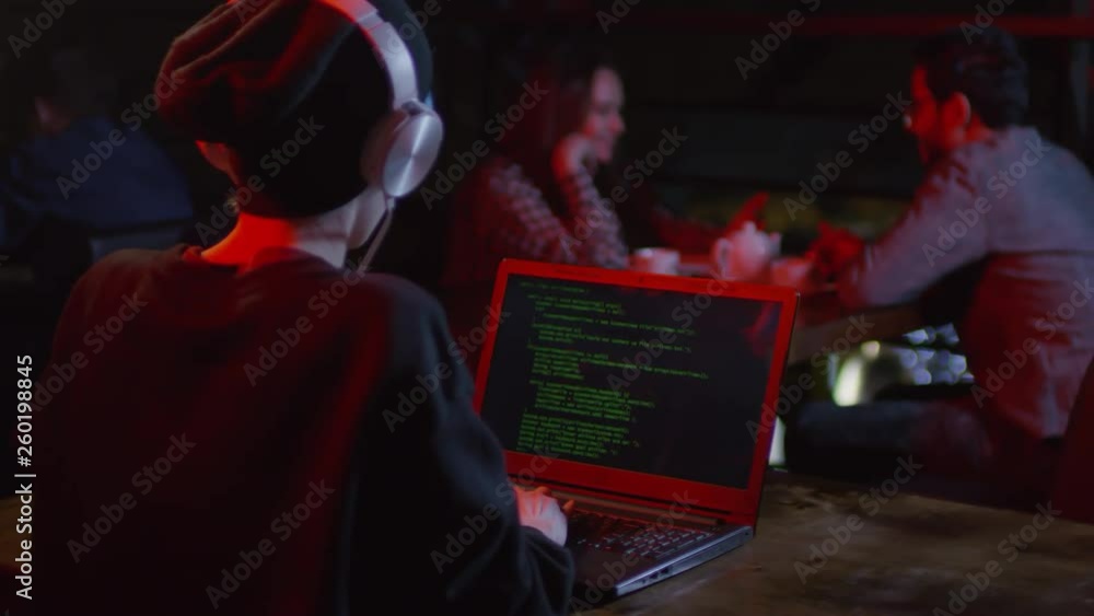 Aufkleber rare view of young woman sitting at computer in bar and developing new computer program