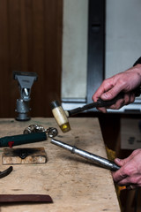 Man doing ring size adjustment with a ring stick and jewelry nylon hammer.