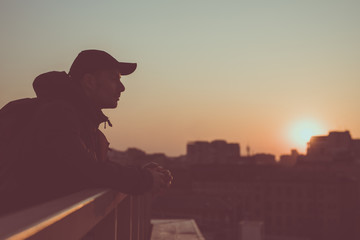 Silhouette of dreaming man in city sunset, toned