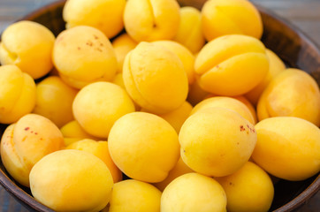 Ripe apricots in a clay bowl.
