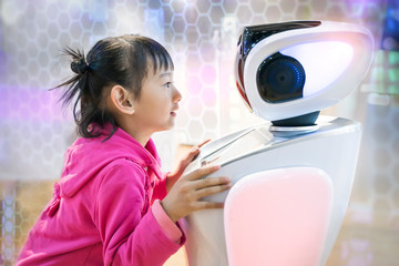 asian child extends a hand to the robot. concept of friendship between the robot and child