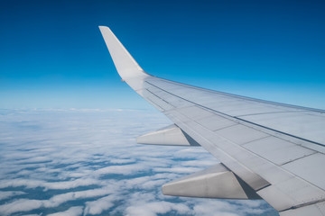 Obraz premium Airplane wing above cloud on the sky ,looking from window of plane