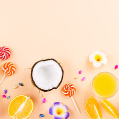 Colorful summer concept flat lay with fresh juice, tropical fruits, lollipops and multicolor seashells, copyspace