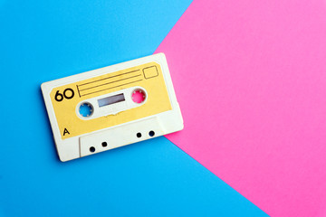 Retro old school 80-s or 90-s concept. Audio cassette on a bright blue-pink background