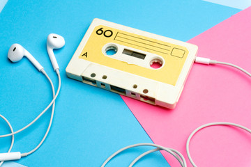 Retro old school 80-s or 90-s concept. Audio cassette on a bright blue-pink background