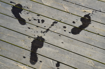 Stockholm, Sweden Wet footprints on a dock in summertime.