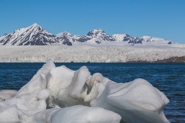 Fototapeta na wymiar ice in front of Esmarkbreen glacier in Svalbard, blue sea and sky