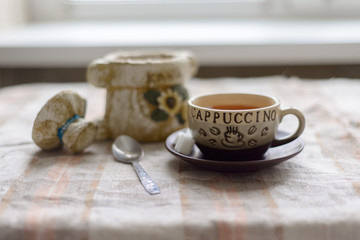 a container for coffee, a cup on a saucer with sugar and a teaspoon