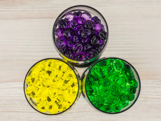 Obraz na płótnie Canvas creating an intimate atmosphere, room decoration: three glasses filled with hydrogel balls of different colors, close, view from the top