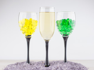 creating an intimate atmosphere, room decoration: a glass of white wine next to 2 glasses filled with hydrogel balls of different colors