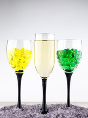 creating an intimate atmosphere, room decoration: a glass of white wine in aromatic salt next to 2 glasses filled with hydrogel balls of different colors