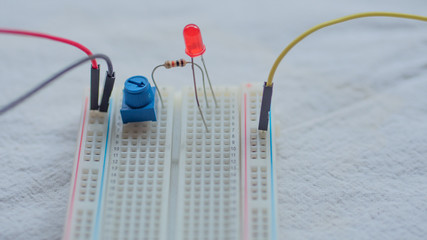 Potentiometer, resistors and red LED set up on a breadboard 
