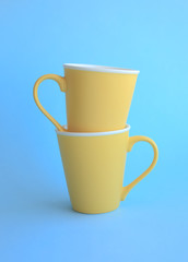Two yellow cups on blue