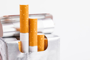 Cigarettes in a pack closeup on white background. Smoking tobacco. Bad habit.