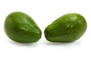 Two whole green avocado fruits on a white background