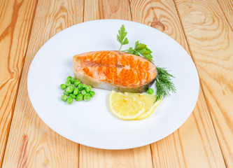 Grilled piece of arctic char and vegetables on white dish