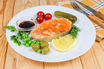 Grilled piece of arctic char with canned vegetables and seasoning