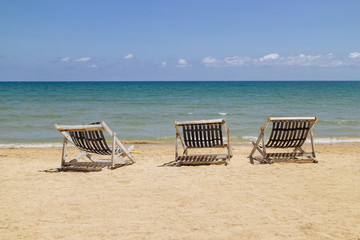 Three folding chairs on the beach with sea and bright sky in the background at Koh Mak in Trat, Thailand. Seasonal Vacation. Background with copy space.