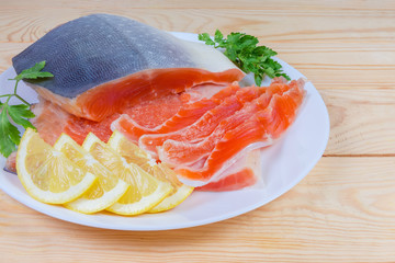Partly sliced salted arctic char on dish on rustic table
