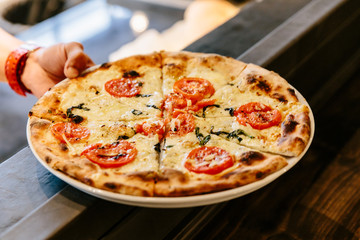 Hot Caprese Bianca Pizza from oven. Ingredients are Mozzarella, Parmesan, Olive oil, sliced tomato and Dough. 