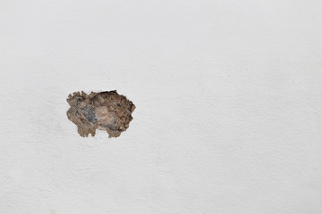 Construction concept background, hole on white cement wall, damaged wall