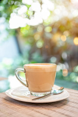 Hot coffee late over blurred garden with vintage morning warm light, coffee shop concept, outdoor day light