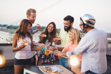 Group of happy friends having party on rooftop