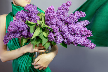 Elegant woman with a huge bouquet of purple lilac