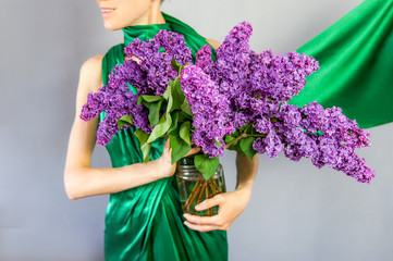 Elegant woman with a huge bouquet of purple lilac