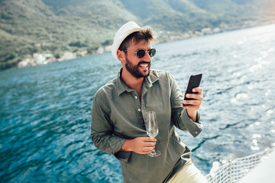 Handsome Man On A Sailing Boat Using Phone.