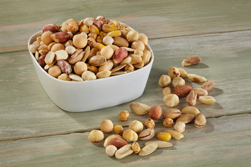 Nut mix in white bowl on wooden background