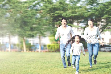 Young attractive happy asian family playing by running together in outside nature park in home school learning or montessori concept with white and blue casual wearing. Asian lifestyle parenting.