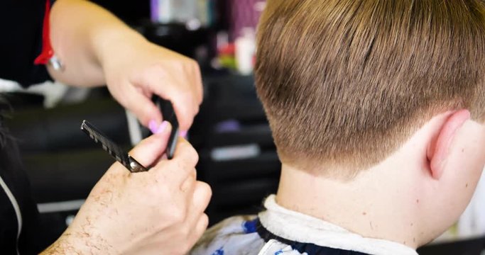 Men's hairstyling and haircutting in a hair salon. Combing and cutting hair. Barbershop.