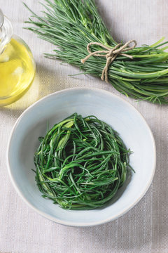 Saltwort  or Sea Beans (Agretti or barba di frate). Italian recipe with olive oil, garlic and anchovies, flat lay. Vegan, Mediterranean, clean eating, dieting food concept