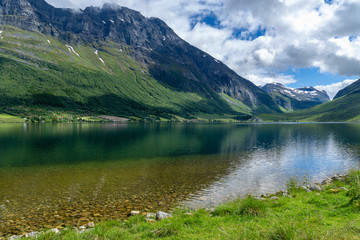 Fototapeta na wymiar Crystal clear lake in a green valley in Norway