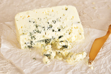 Fresh blue cheese on a golden saucer, honey and grapes.