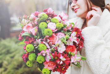 beautiful young woman with a large bouquet of flowers in the park