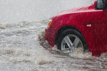 Street in the heavy rain - flood road . red car moving