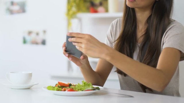 Girl making photos of vegetable salad before eating, food blogger, culinary tips
