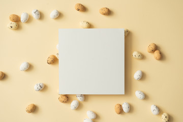 Easter eggs on pastel yellow background with paper card note. Easter holiday concept. Minimal composition.