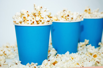 Blue glasses with popcorn on a white background
