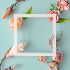 Easter composition made with flowers and eggs on bright blue background with ribbon copy space....