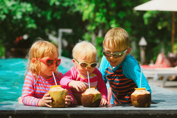 happy kids drinking coconut cocktail on beach resort