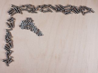 Chrome plated bolts and nuts on a wooden background with copy space for your own text